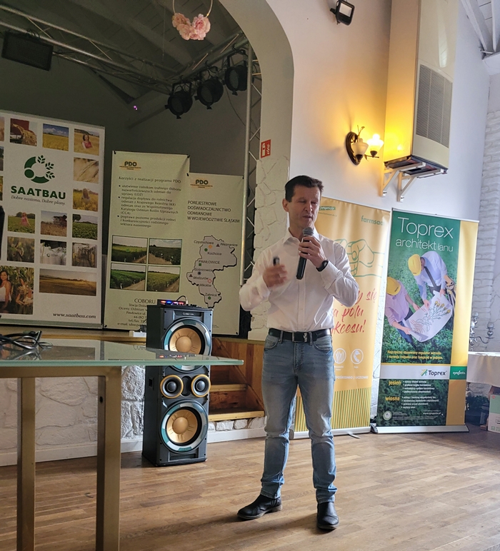 Na zdjęciu znajduje się przedstawiciel firmy Farmsaat, który opowiada o uprawach kukurydzy